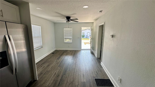 interior space with ceiling fan, dark wood-type flooring, and a textured ceiling