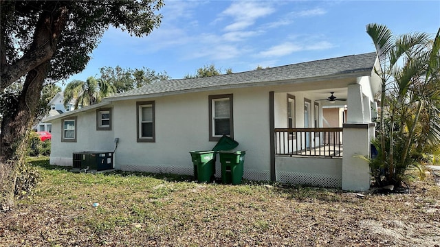 exterior space with central AC unit, a yard, and ceiling fan