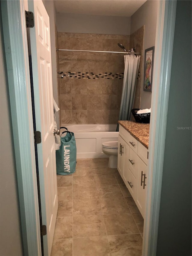 full bathroom featuring toilet, tile patterned flooring, shower / bath combo with shower curtain, and vanity