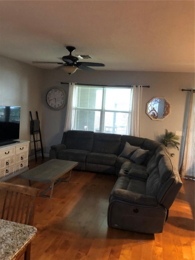 living room featuring wood finished floors, visible vents, and a ceiling fan