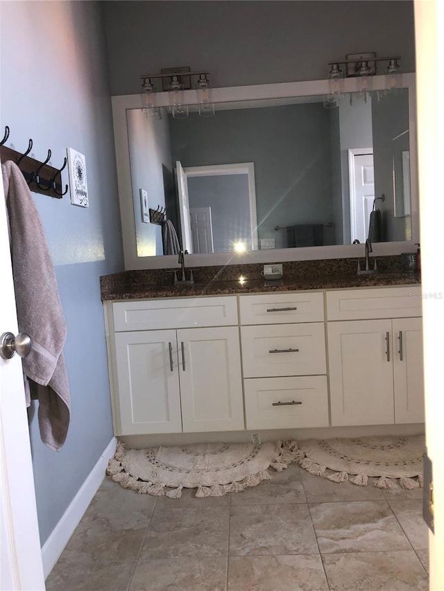 bathroom featuring double vanity, marble finish floor, and a sink