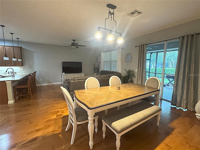 dining area featuring ceiling fan, dark wood-style flooring, visible vents, and baseboards