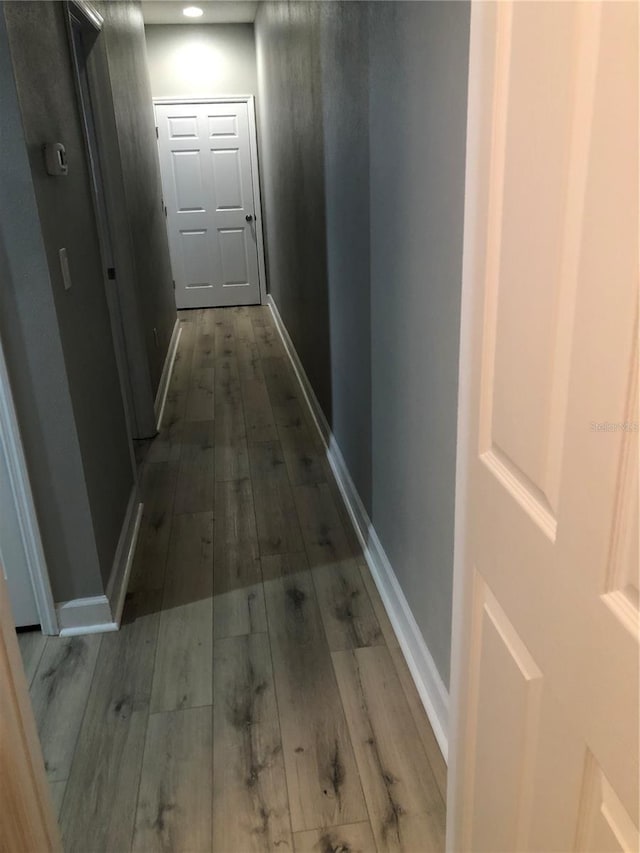 hallway with baseboards and wood finished floors