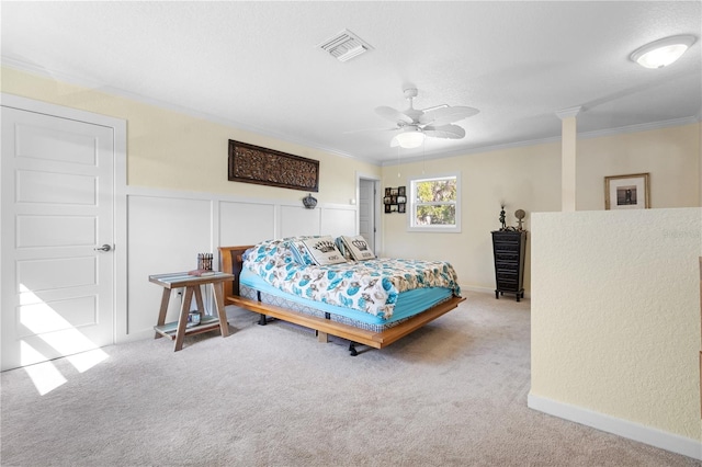 carpeted bedroom featuring ornamental molding, decorative columns, and ceiling fan