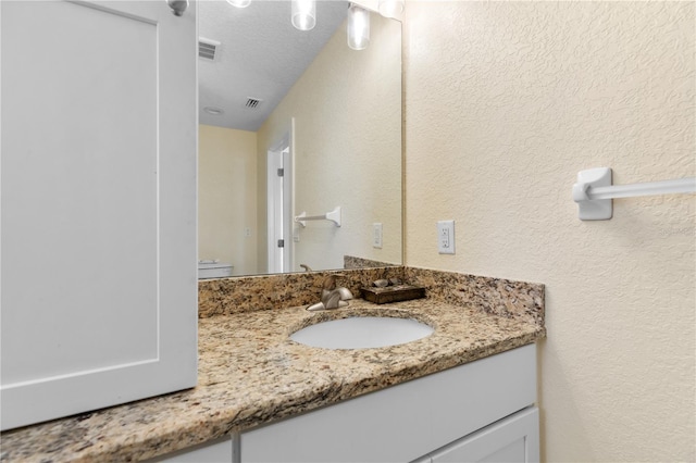 bathroom with vanity and a textured ceiling