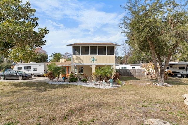 view of front facade with a front lawn, a sunroom, and a porch