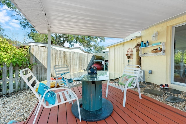 wooden deck with a fenced backyard and outdoor dining area