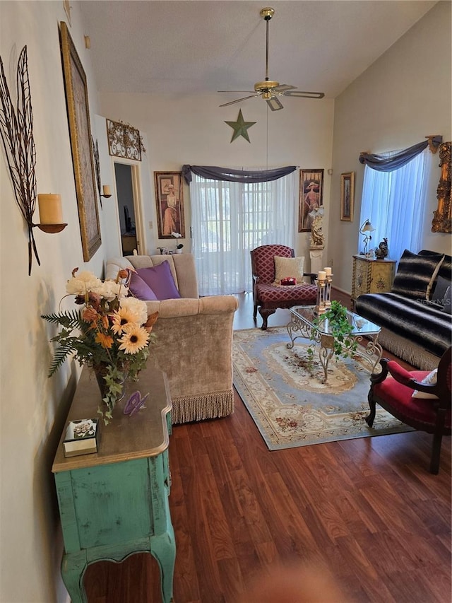 living room with lofted ceiling, dark wood-type flooring, and ceiling fan