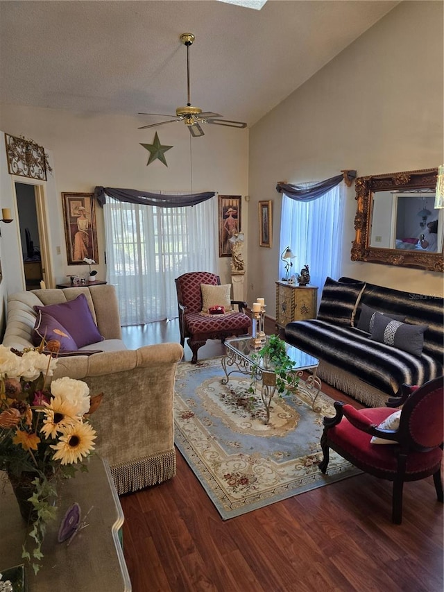 living room featuring a textured ceiling, dark wood-type flooring, high vaulted ceiling, and ceiling fan