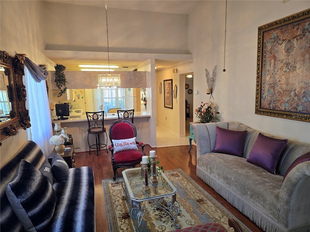 living room featuring a towering ceiling, hardwood / wood-style floors, and a chandelier