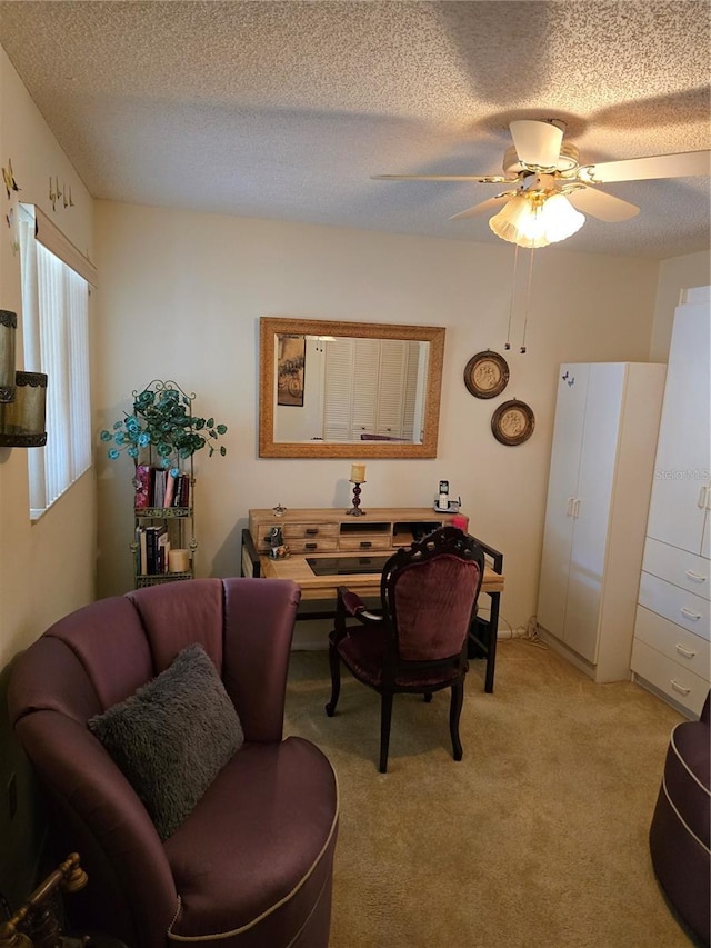 living room with ceiling fan, light colored carpet, and a textured ceiling