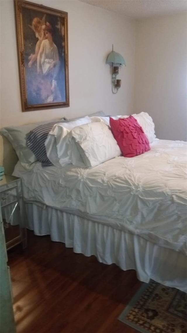 bedroom with dark hardwood / wood-style flooring