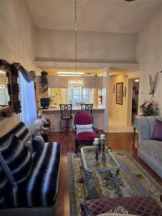 living room with an inviting chandelier, wood-type flooring, and a high ceiling