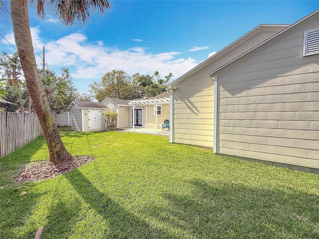 view of yard featuring a storage shed and a patio area