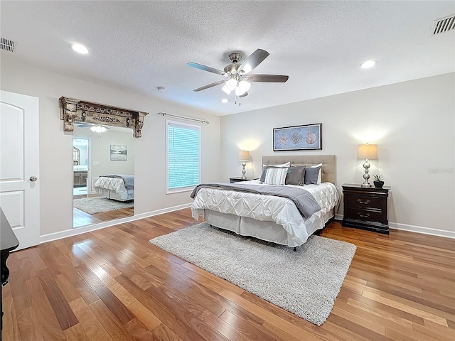 bedroom featuring hardwood / wood-style flooring, ceiling fan, and a textured ceiling