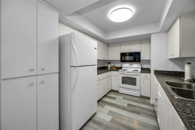 kitchen featuring sink, white appliances, light hardwood / wood-style flooring, white cabinetry, and a tray ceiling