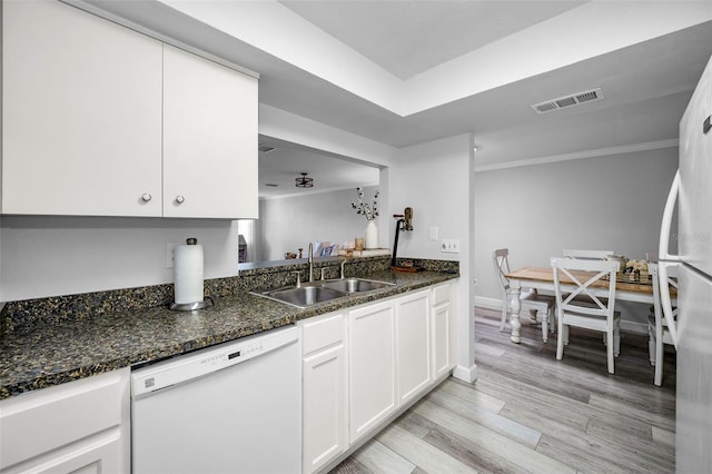 kitchen with white cabinetry, sink, white appliances, and dark stone counters