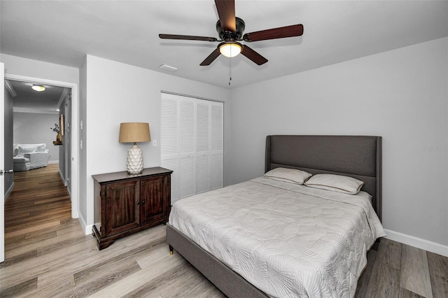 bedroom featuring light hardwood / wood-style floors, a closet, and ceiling fan