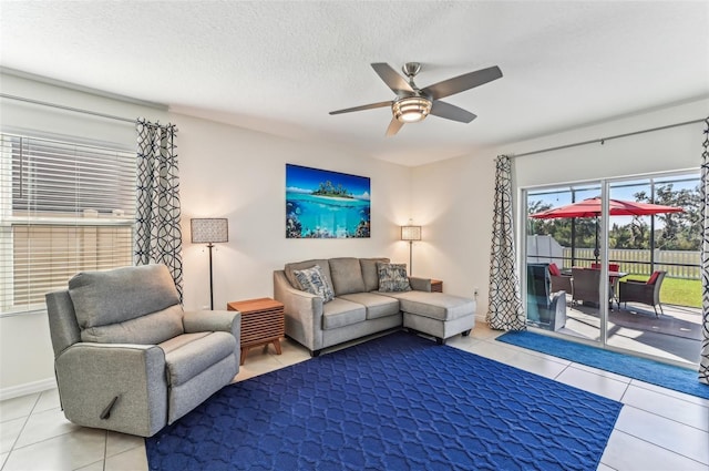 tiled living room with ceiling fan and a textured ceiling