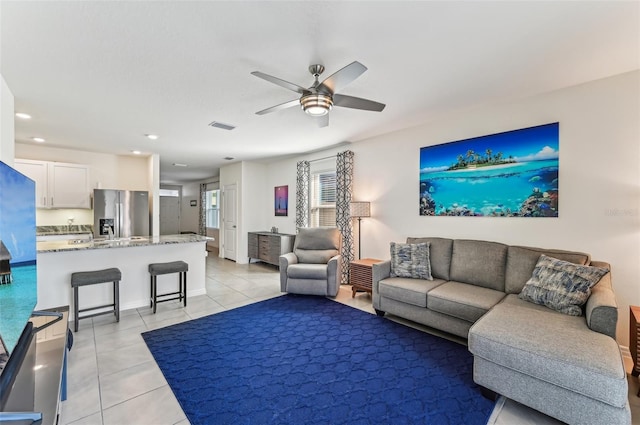 living room featuring light tile patterned floors and ceiling fan