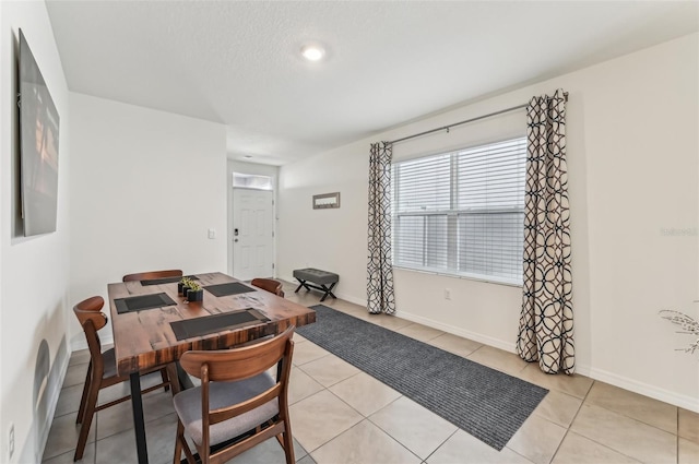 tiled dining area featuring a textured ceiling