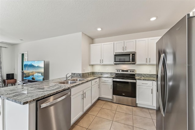 kitchen featuring appliances with stainless steel finishes, kitchen peninsula, and white cabinets