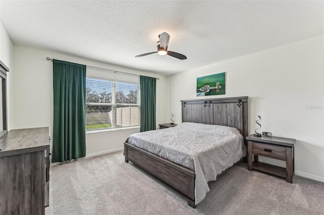 carpeted bedroom with ceiling fan and a textured ceiling