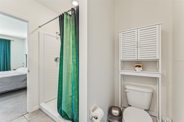 bathroom with tile patterned flooring, a shower with curtain, and toilet