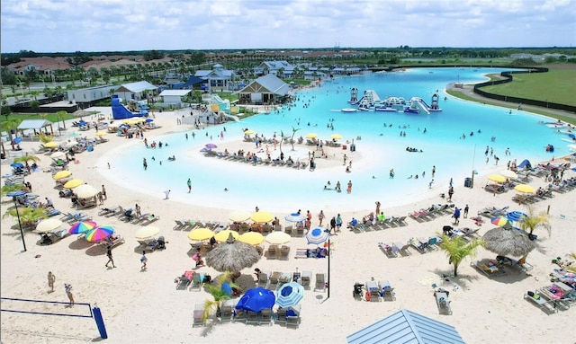 birds eye view of property with a water view and a beach view