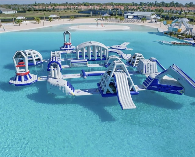 view of pool featuring a beach view and a water view