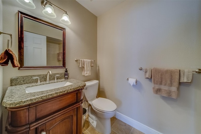 bathroom with baseboards, vanity, toilet, and tile patterned floors