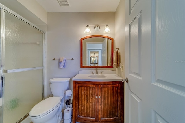 bathroom featuring visible vents, a stall shower, vanity, and toilet