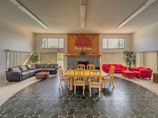 dining area featuring stone finish floor and a stone fireplace