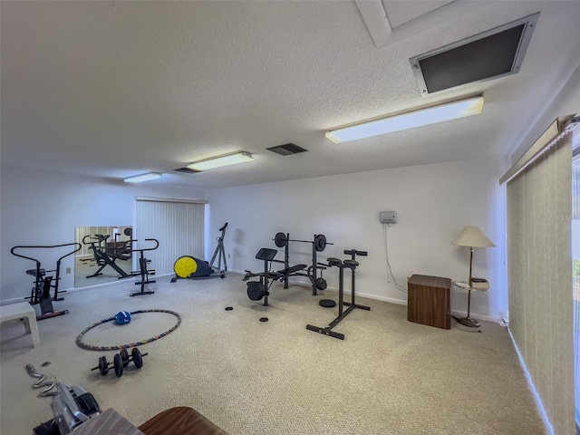 exercise room with baseboards and a textured ceiling