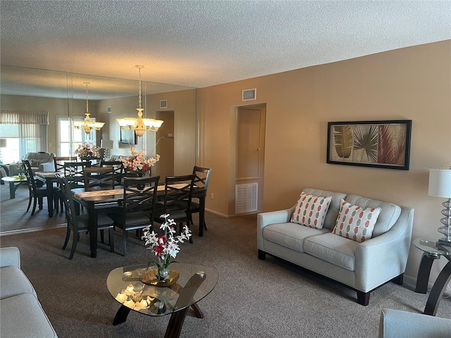 carpeted living room with a notable chandelier and a textured ceiling