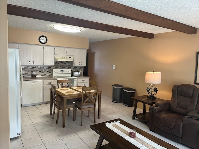 dining area with beamed ceiling, light tile patterned flooring, and a textured ceiling