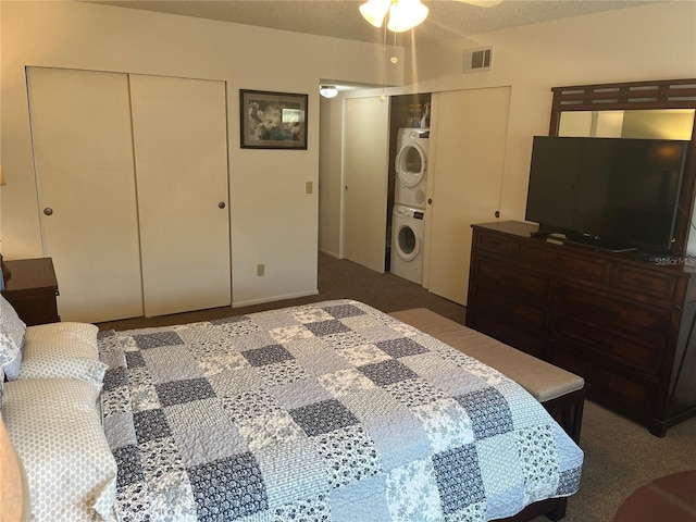 bedroom with carpet, stacked washer / drying machine, and a textured ceiling