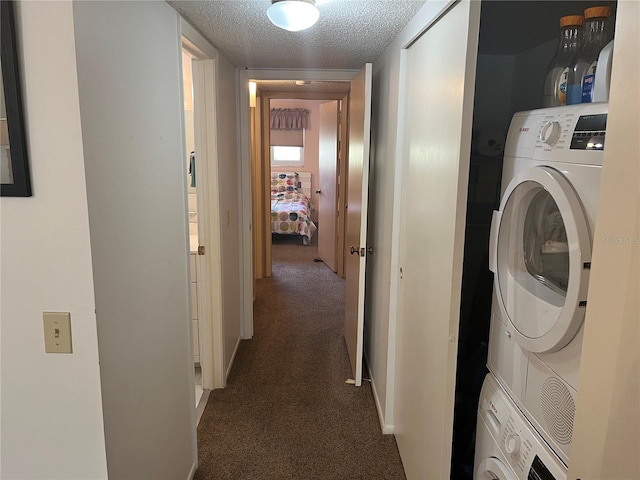 laundry room featuring stacked washer and clothes dryer, a textured ceiling, and dark colored carpet