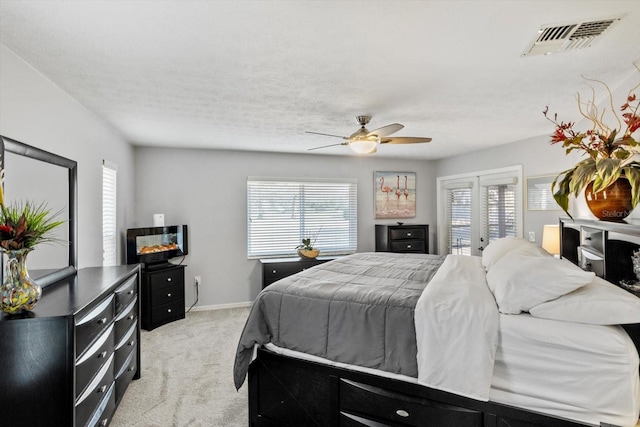 carpeted bedroom featuring multiple windows, ceiling fan, and a textured ceiling