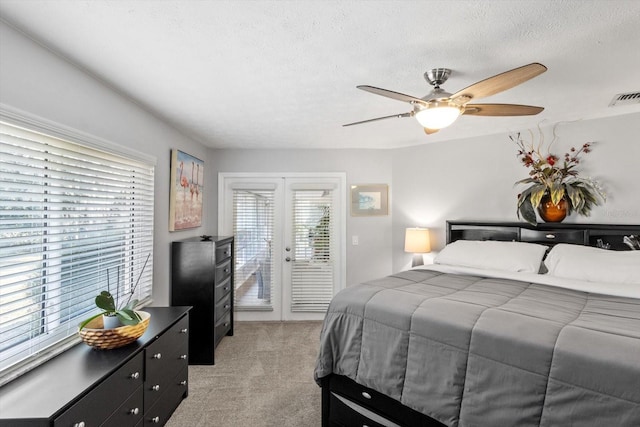 carpeted bedroom with french doors, ceiling fan, a textured ceiling, and access to outside