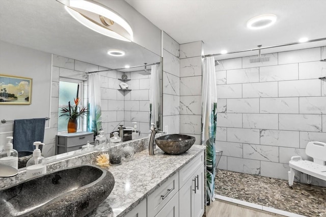 bathroom featuring hardwood / wood-style flooring, vanity, and walk in shower