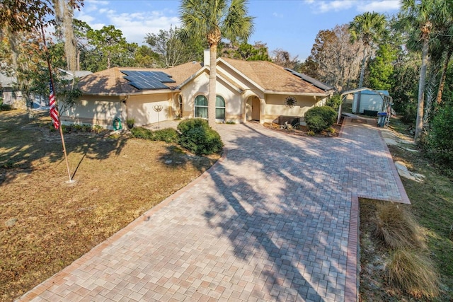 ranch-style home featuring solar panels