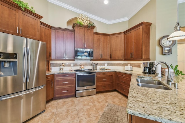 kitchen featuring sink, crown molding, pendant lighting, stainless steel appliances, and light stone countertops