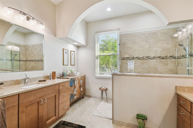 bathroom featuring tiled shower and vanity