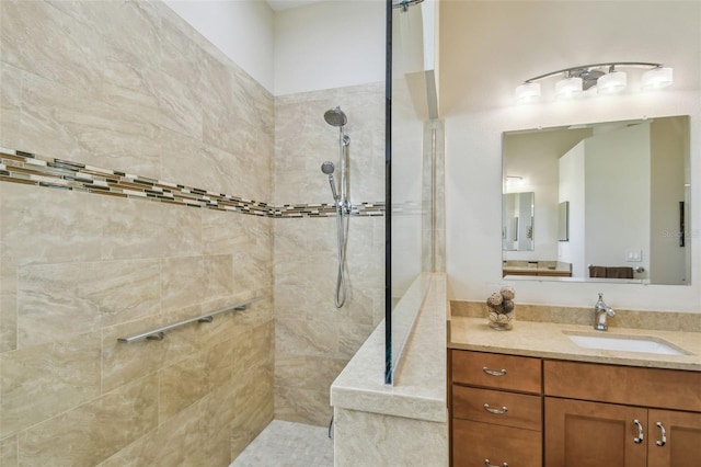 bathroom featuring tiled shower and vanity