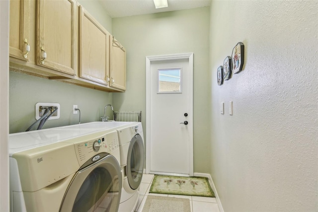 laundry area with cabinets, light tile patterned flooring, and washer and clothes dryer