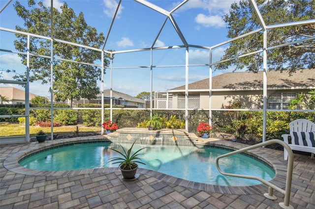 view of pool with pool water feature, a patio, and glass enclosure