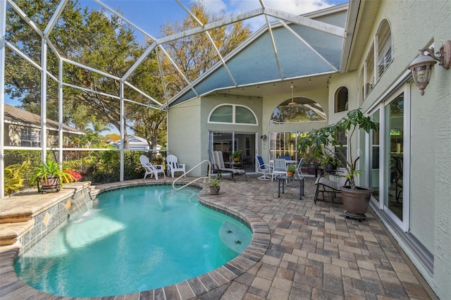 view of swimming pool featuring pool water feature, a lanai, and a patio