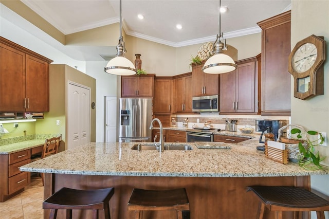 kitchen featuring sink, decorative light fixtures, stainless steel appliances, and kitchen peninsula