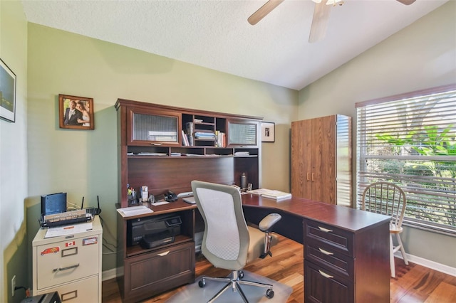 office space with hardwood / wood-style flooring, ceiling fan, vaulted ceiling, and a textured ceiling